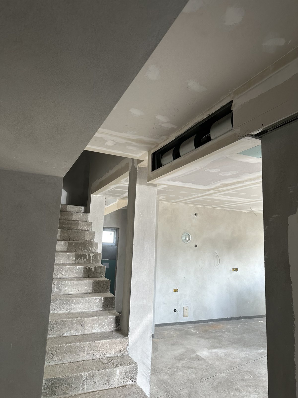 Spušteni plafon sa skrivačem za ventilacione cevi pored betonskog stepeništa — gipsarski radovi Novi Sad