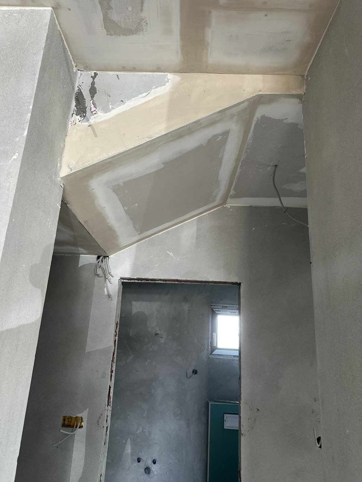 Spušteni plafon sa kosim geometrijskim prelomom u manjoj prostoriji — gipsarski radovi Novi Sad