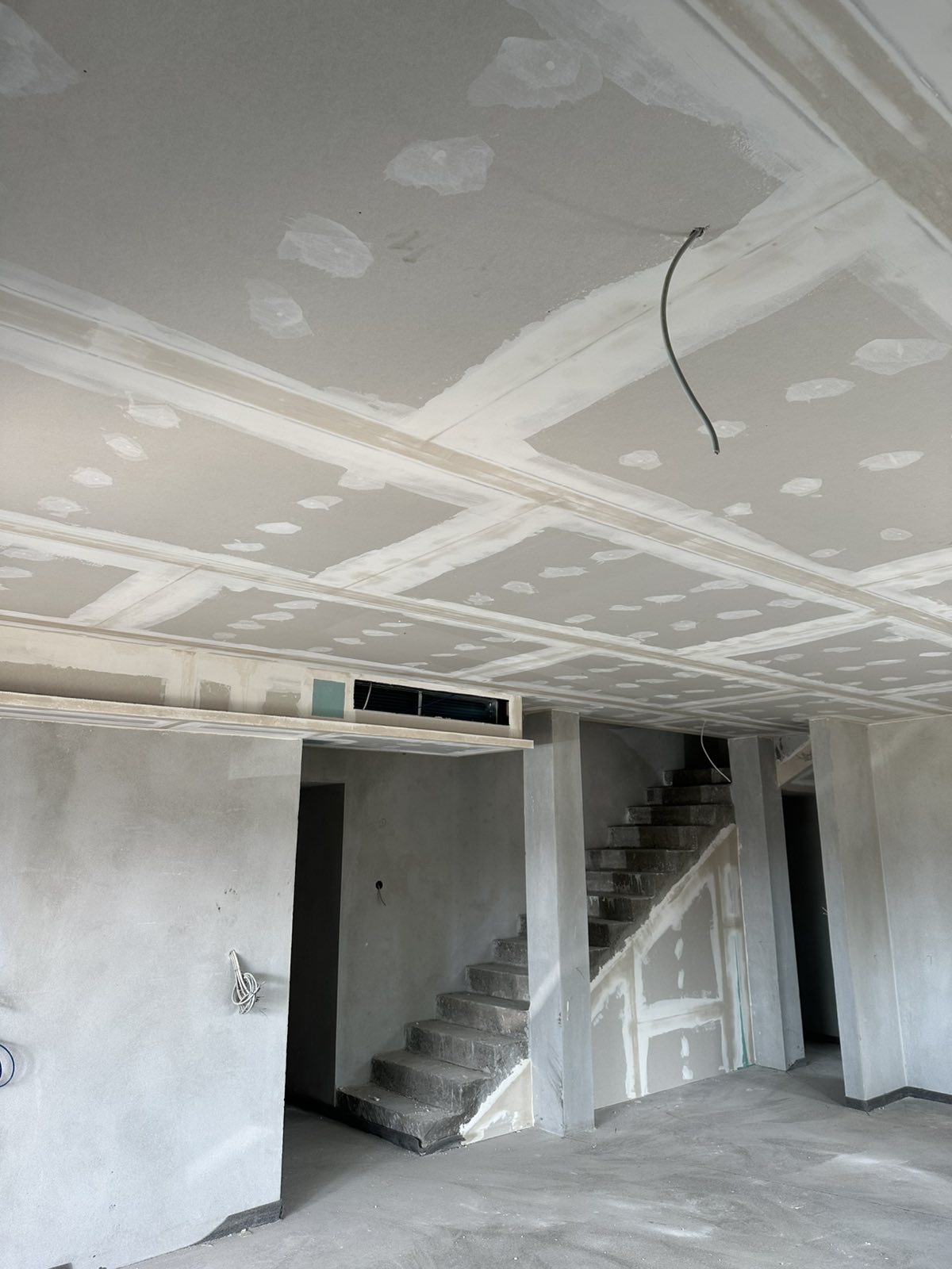 Veliki kasetni spušteni plafon u dnevnom boravku sa betonskim stepeništem — gipsarski radovi Novi Sad